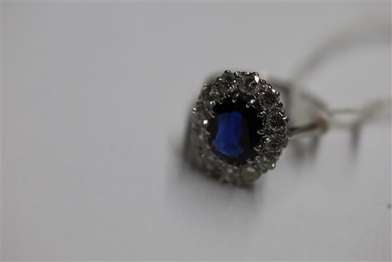 A modern white gold?, sapphire and diamond set oval cluster ring, size N.